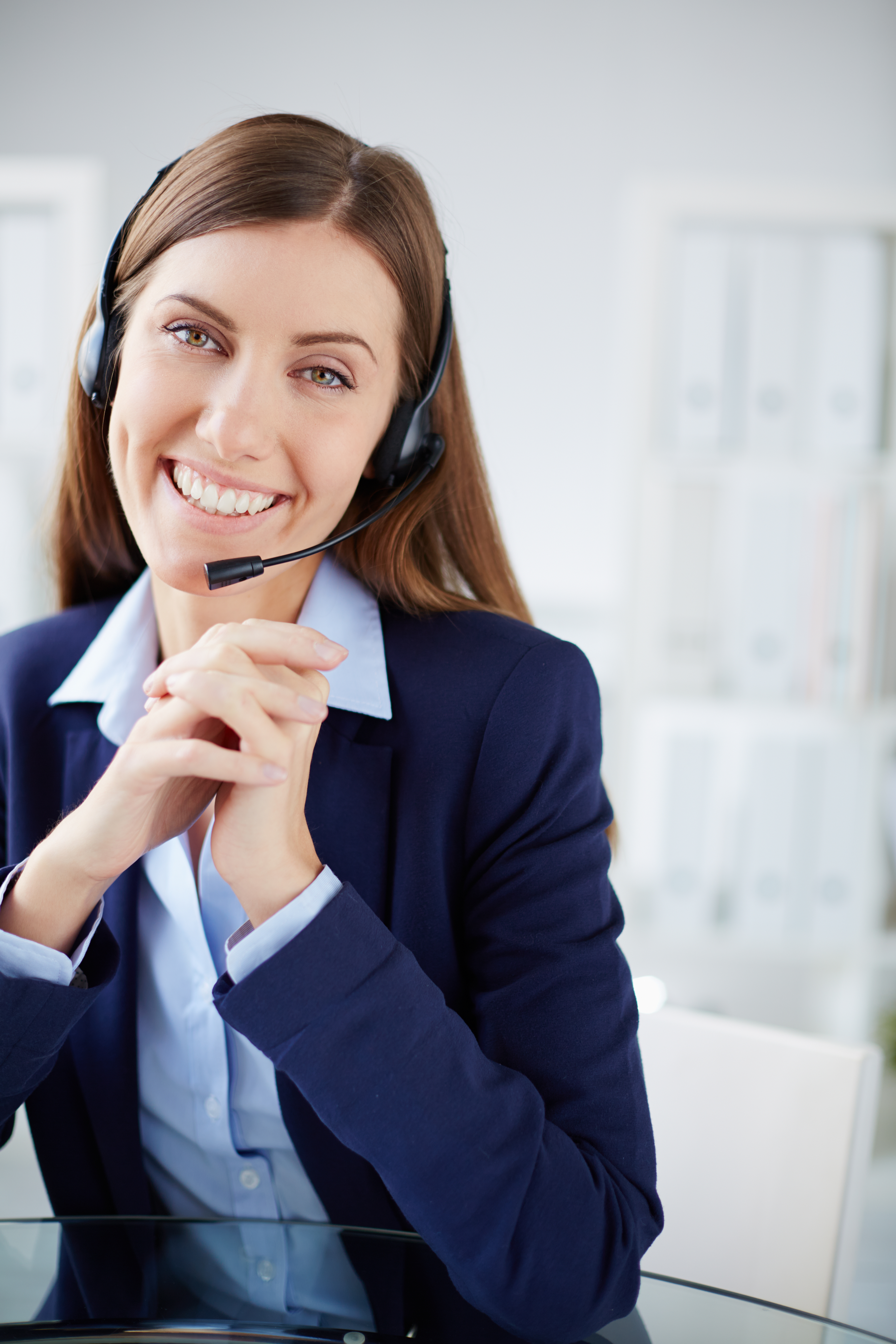 Young businesswoman with headset looking at camera with smile